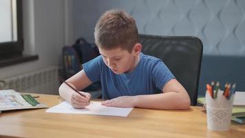 Little cute boy draws with pencils is engaged in creativity at home or in school photo