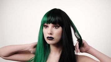 portrait of woman with a green black hair wig straightens long hair photo