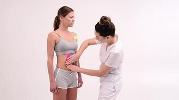 El terapeuta aplica cinta de kinesio al cuerpo femenino. conceptos de fisioterapia y kinesiología. foto
