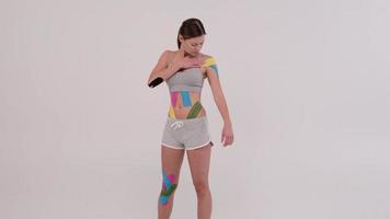 Hermosa joven atleta posando colorido kinesiotape en su cuerpo foto