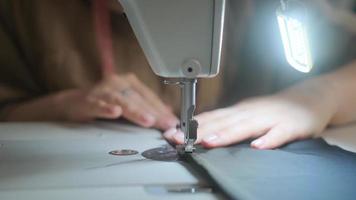 Stitching on sewing machine. Tailor sews on sewing machine. Close-up of woman's hand and sewing process. photo