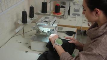 costurera trabaja en la máquina de coser. sastre se sienta a la mesa y garabatea en la máquina de coser.