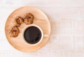 Black coffee with cookies on wood photo