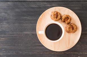 Black coffee with cookies on wood photo