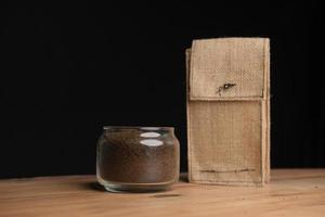 Loose tea in a glass jar and a organic bag on table . photo