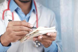 doctor hand writing prescription on desk, close up. photo