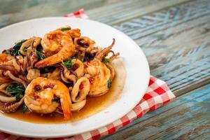 Stir-fried seafood of shrimp and squid with Thai basil - Asian food style photo