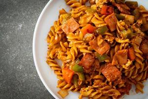 Stir-fried fusilli pasta with ham and tomato sauce photo