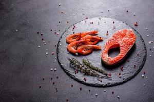 Filete de pescado rojo trucha cruda servido con hierbas y limón foto