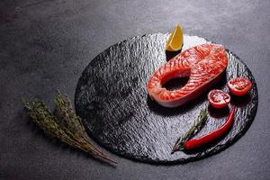 Filete de pescado rojo trucha cruda servido con hierbas y limón foto