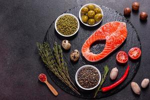 Raw trout red fish steak served with herbs and lemon photo