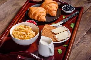 delicioso desayuno con croissants recién hechos y bayas maduras foto