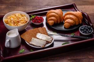 delicioso desayuno con croissants recién hechos y bayas maduras foto