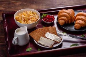 Delicious breakfast with fresh croissants and ripe berries photo