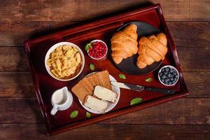 delicioso desayuno con croissants recién hechos y bayas maduras foto