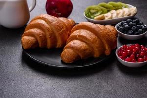 Delicious breakfast with fresh croissants and ripe berries photo