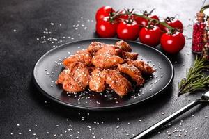 Filete de pollo en ajonjolí, salsa teriyaki sobre plato de piedra negra