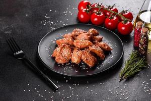 Chicken fillet in sesame seeds, teriyaki sauce on a black stone plate photo