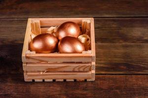 Huevos de Pascua en caja de madera de regalo sobre fondo de madera oscura. foto