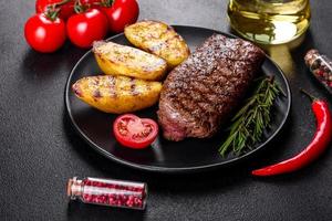 Ribeye steak with potatoes, onions and cherry tomatoes photo