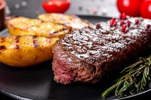 Ribeye steak with potatoes, onions and cherry tomatoes photo