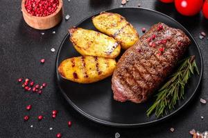 Ribeye steak with potatoes, onions and cherry tomatoes photo