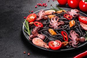 Black seafood pasta with shrimp, octopus and mussels photo