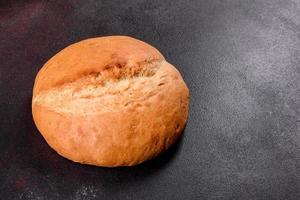 Fresh baked white bread on a brown concrete background