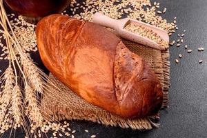 Fresh baked brown bread on a brown concrete background photo