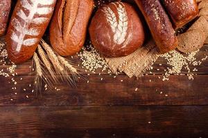 Fresh baked brown bread on a brown wooden background photo