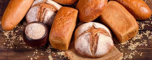 Fresh baked brown bread on a brown wooden background photo