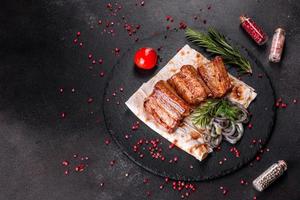 Costillas fritas con romero, cebolla, salsa sobre un fondo de hormigón foto