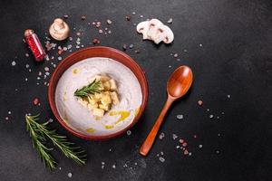 Delicious beautiful mushroom soup in a brown plate with a wooden spoon photo