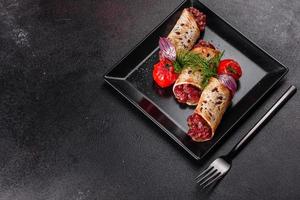 Delicious fresh beef tartar with toasts on a black square plate photo