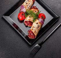 Delicious fresh beef tartar with toasts on a black square plate photo