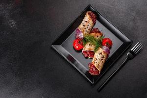 Delicious fresh beef tartar with toasts on a black square plate photo