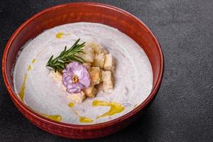 deliciosa sopa de hongos hermosa en un plato marrón con una cuchara de madera foto