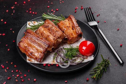 Costillas fritas con romero, cebolla, salsa sobre un fondo de hormigón foto