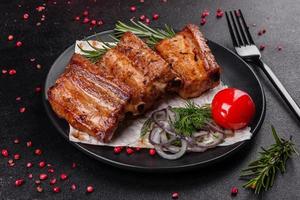 Costillas fritas con romero, cebolla, salsa sobre un fondo de hormigón foto