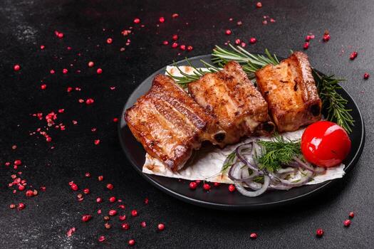 Costillas fritas con romero, cebolla, salsa sobre un fondo de hormigón foto