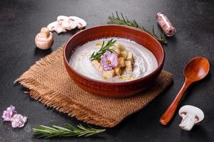 Delicious beautiful mushroom soup in a brown plate with a wooden spoon photo