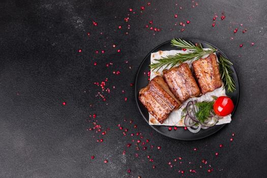 Costillas fritas con romero, cebolla, salsa sobre un fondo de hormigón foto