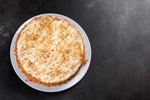 Fresh delicious carrot cake with cream on a dark background photo