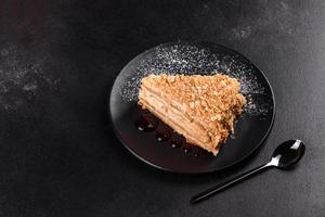 Fresh delicious cake napoleon with cream on a dark background photo