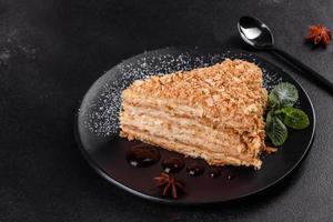 Fresh delicious cake napoleon with cream on a dark background photo