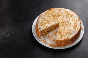 Fresh delicious carrot cake with cream on a dark background photo