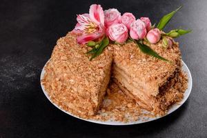 Fresh delicious cake napoleon with cream on a dark background photo