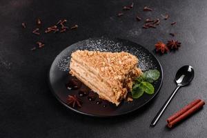 Fresh delicious cake napoleon with cream on a dark background photo