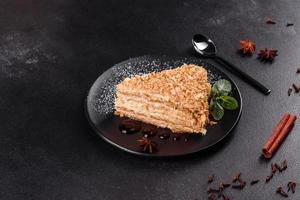 Fresh delicious cake napoleon with cream on a dark background photo