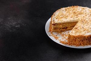 Fresh delicious carrot cake with cream on a dark background photo